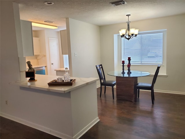 13002 Nantucket Dr, Sugar Land, TX 77478 - dining space featuring a textured ceiling, baseboards, a notable chandelier, dark wood-type flooring, and visible vents