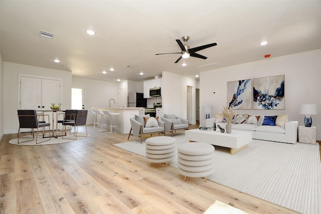 living area featuring ceiling fan, recessed lighting, visible vents, and light wood-type flooring