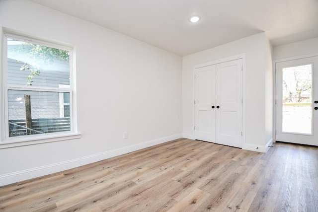 interior space with light wood-style flooring, a wealth of natural light, and baseboards