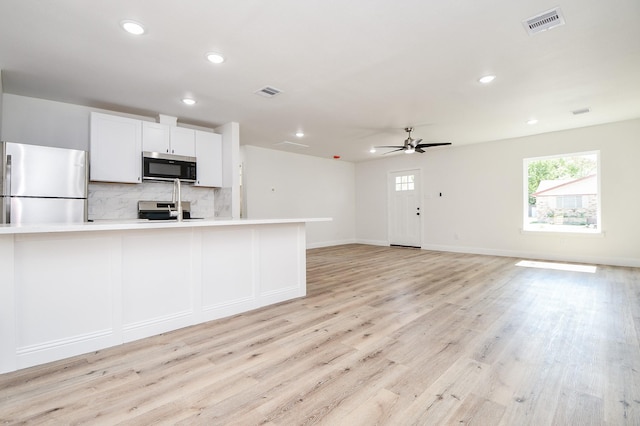 kitchen featuring recessed lighting, light wood-type flooring, decorative backsplash, appliances with stainless steel finishes, and ceiling fan