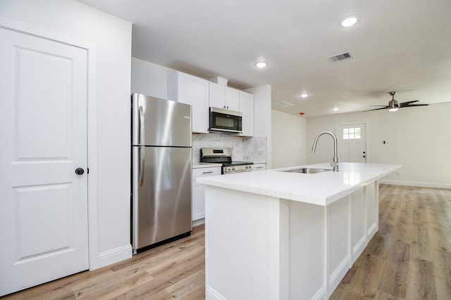 kitchen featuring light wood finished floors, visible vents, appliances with stainless steel finishes, and a sink