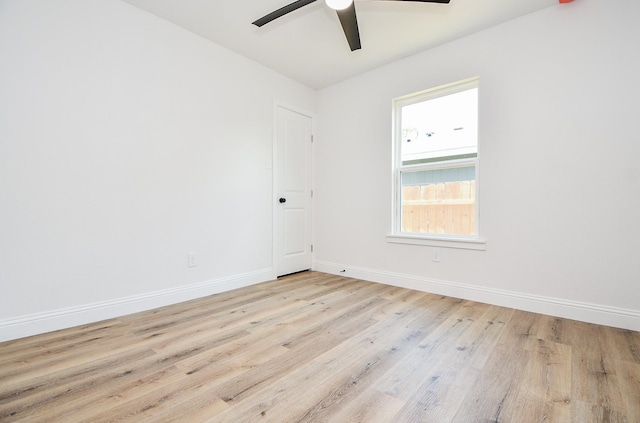 spare room featuring baseboards, wood finished floors, and ceiling fan