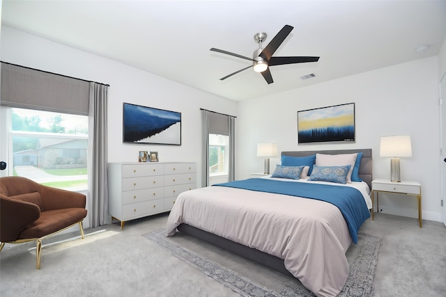 bedroom featuring visible vents, a ceiling fan, light colored carpet, and multiple windows