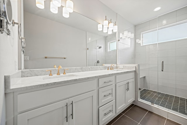 bathroom with tile patterned floors, double vanity, a stall shower, and a sink