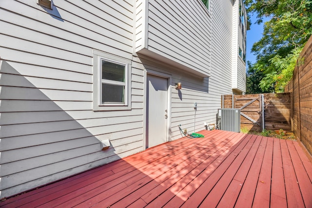 wooden terrace with central AC unit, a fenced backyard, and a gate