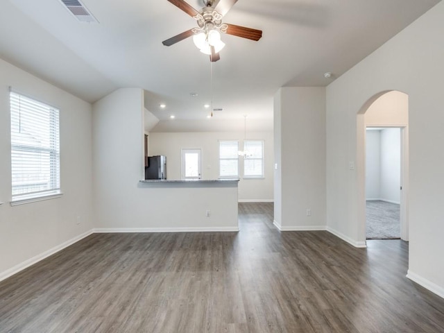 13088 Laura Lake Dr, Willis, TX 77318 - unfurnished living room featuring dark wood-type flooring, arched walkways, a ceiling fan, visible vents, and baseboards