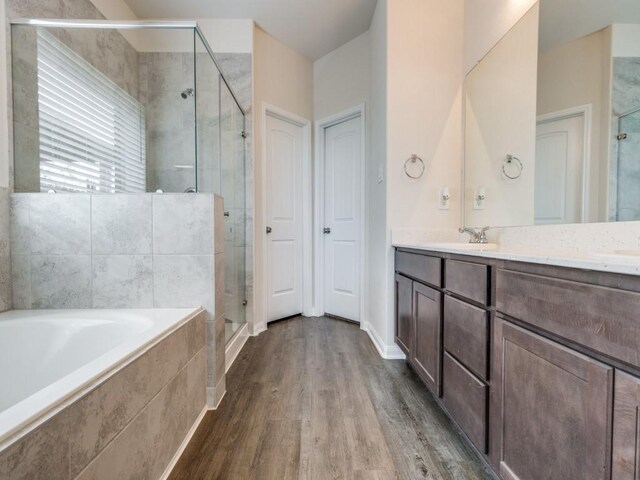 13088 Laura Lake Dr, Willis, TX 77318 - bathroom featuring a garden tub, a shower stall, wood finished floors, a sink, and double vanity