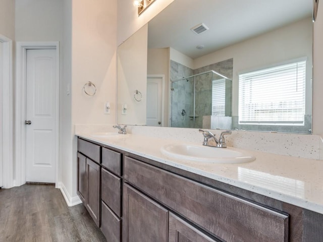13088 Laura Lake Dr, Willis, TX 77318 - full bath featuring a shower stall, wood finished floors, a sink, and visible vents