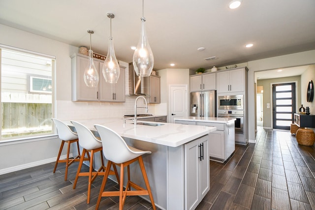 11115 Elderflower Dr, Missouri City, TX 77459 - kitchen featuring stainless steel appliances, baseboards, a peninsula, wood finish floors, and tasteful backsplash