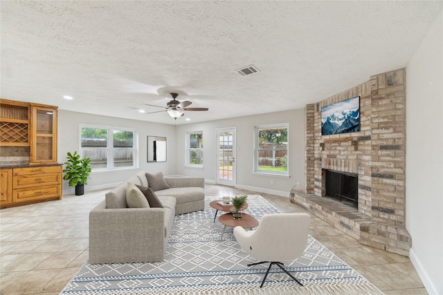 4010 Bluebonnet Trl, Deer Park, TX 77536 - living room with light tile patterned flooring, a fireplace, a ceiling fan, a textured ceiling, and recessed lighting