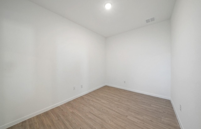 10710 Sora Dr, Willis, TX 77378 - spare room featuring baseboards and light wood-type flooring