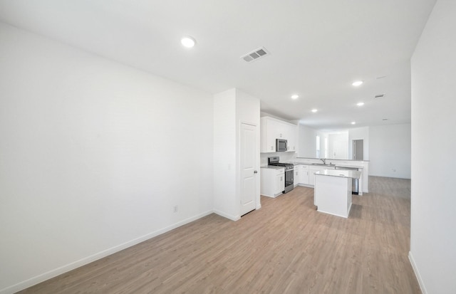 10710 Sora Dr, Willis, TX 77378 - kitchen featuring appliances with stainless steel finishes, open floor plan, light wood-style floors, baseboards, and recessed lighting