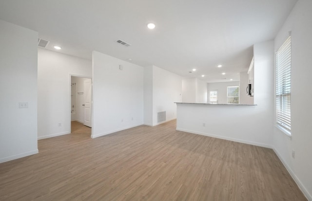 10710 Sora Dr, Willis, TX 77378 - unfurnished living room with light wood-type flooring, baseboards, and recessed lighting