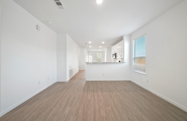 10710 Sora Dr, Willis, TX 77378 - unfurnished living room featuring light wood-style floors, baseboards, and recessed lighting