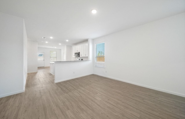 10710 Sora Dr, Willis, TX 77378 - unfurnished living room featuring light wood-style flooring, recessed lighting, and baseboards