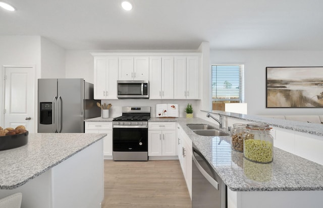 10710 Sora Dr, Willis, TX 77378 - kitchen featuring appliances with stainless steel finishes, a sink, recessed lighting, a peninsula, and white cabinetry