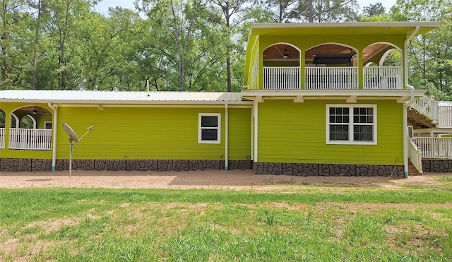 rear view of house featuring a balcony, metal roof, ceiling fan, and stairway