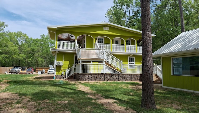 back of house featuring a lawn, stairway, and a porch