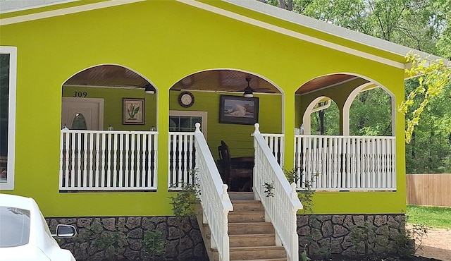 exterior space with covered porch and stone siding