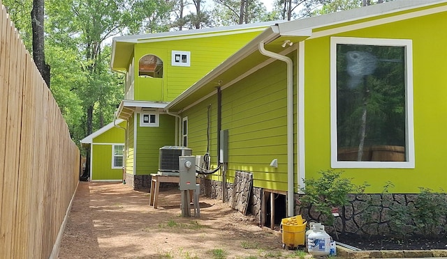view of property exterior with fence and central AC