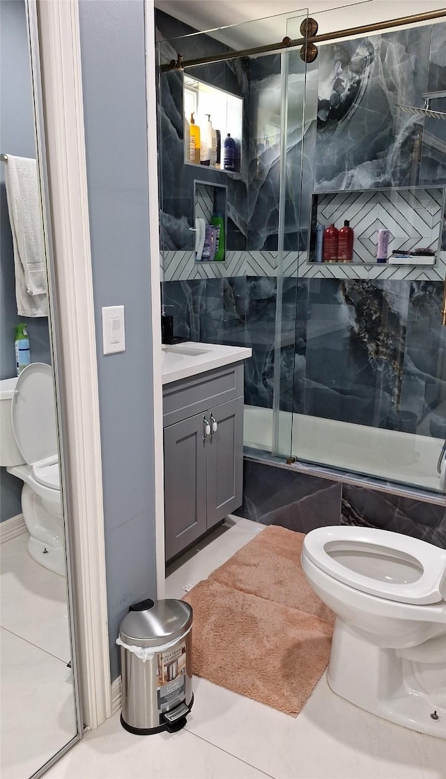 full bathroom with tile patterned floors, enclosed tub / shower combo, toilet, and vanity