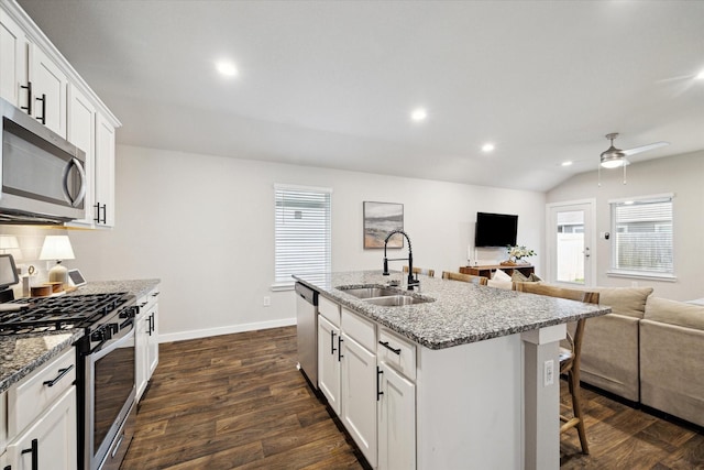 9833 Glen Brook Ln, Magnolia, TX 77354 - kitchen with stainless steel appliances, recessed lighting, a ceiling fan, open floor plan, and a kitchen bar