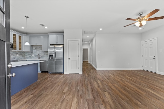 1603 Oleander Dr, La Marque, TX 77568 - kitchen with stainless steel fridge, light countertops, dark wood finished floors, a ceiling fan, and decorative backsplash