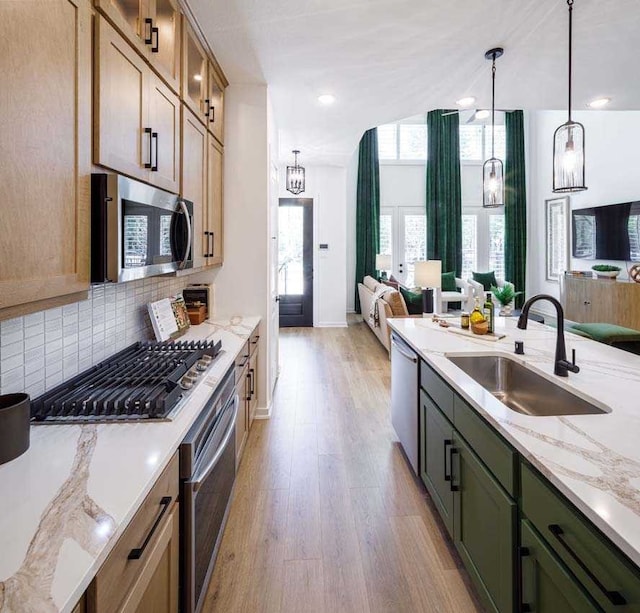 211 Cypress Pond Pl, Montgomery, TX 77316 - kitchen featuring open floor plan, tasteful backsplash, a sink, light wood-style flooring, and appliances with stainless steel finishes