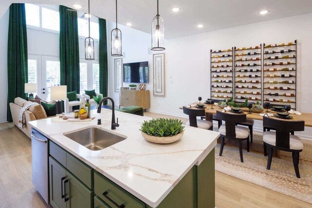211 Cypress Pond Pl, Montgomery, TX 77316 - kitchen with green cabinets, a sink, dishwasher, and an island with sink