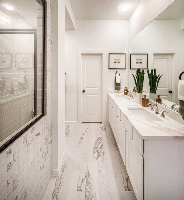211 Cypress Pond Pl, Montgomery, TX 77316 - bathroom with tiled shower, a sink, marble finish floor, baseboards, and double vanity