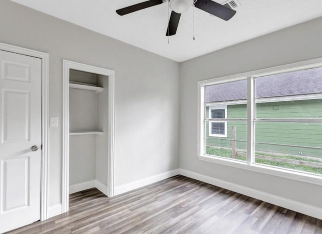 unfurnished bedroom featuring baseboards, visible vents, wood finished floors, and a closet