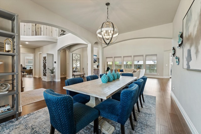dining area featuring plenty of natural light, baseboards, arched walkways, and a chandelier