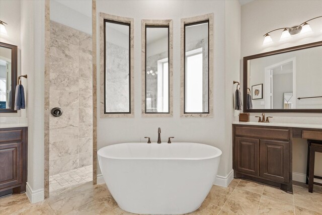 bathroom with a freestanding bath, baseboards, vanity, and a walk in shower