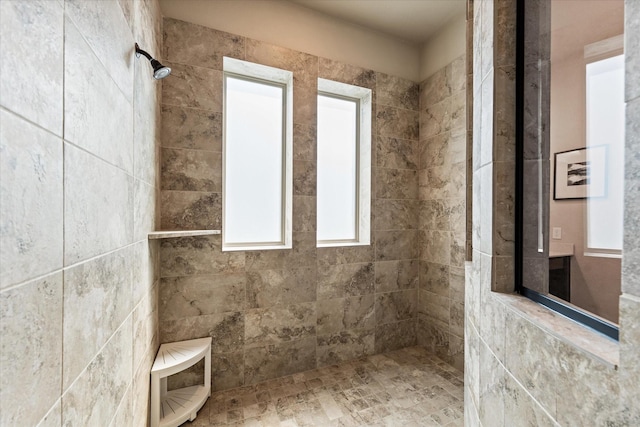 bathroom featuring a tile shower and plenty of natural light