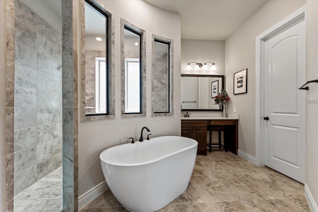 full bathroom featuring walk in shower, a soaking tub, vanity, and baseboards