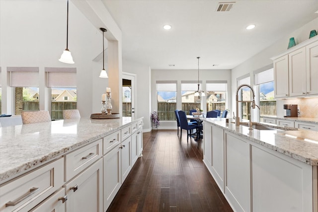 kitchen featuring a sink, white cabinets, dark wood-style flooring, visible vents, and recessed lighting