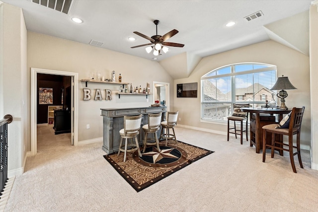 dining area featuring carpet floors, visible vents, a bar, and baseboards