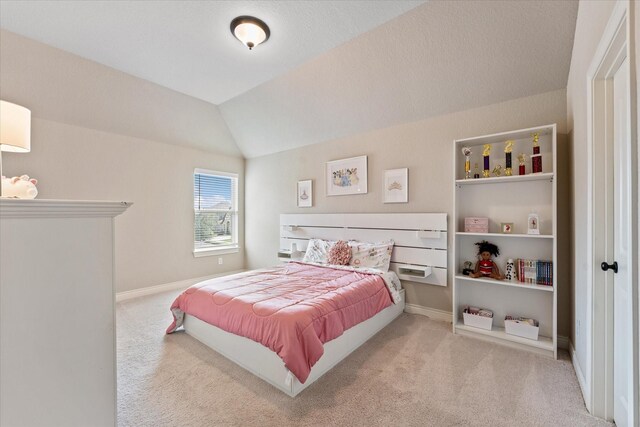 carpeted bedroom with vaulted ceiling and baseboards