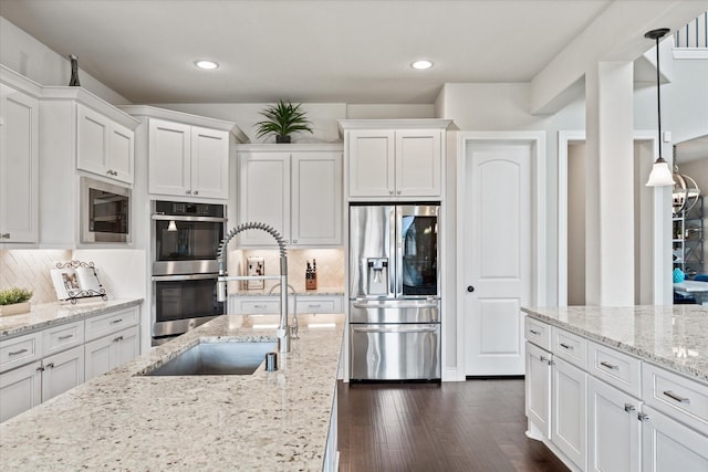 kitchen with recessed lighting, white cabinetry, stainless steel appliances, and a sink