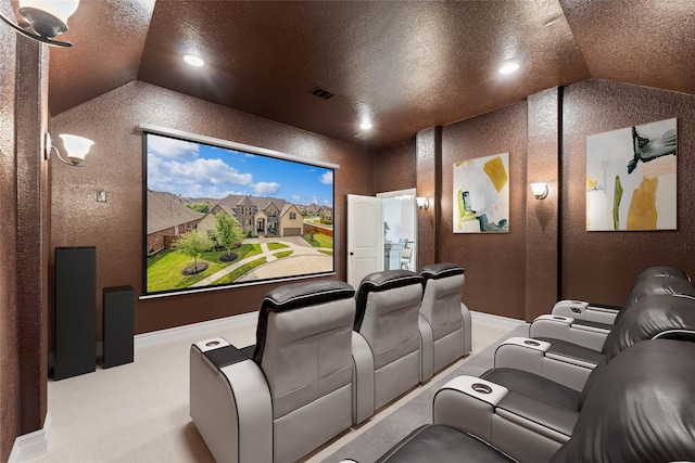 home theater room with a textured ceiling, a textured wall, light colored carpet, lofted ceiling, and visible vents