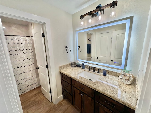full bathroom featuring wood finished floors, vanity, and a shower with curtain