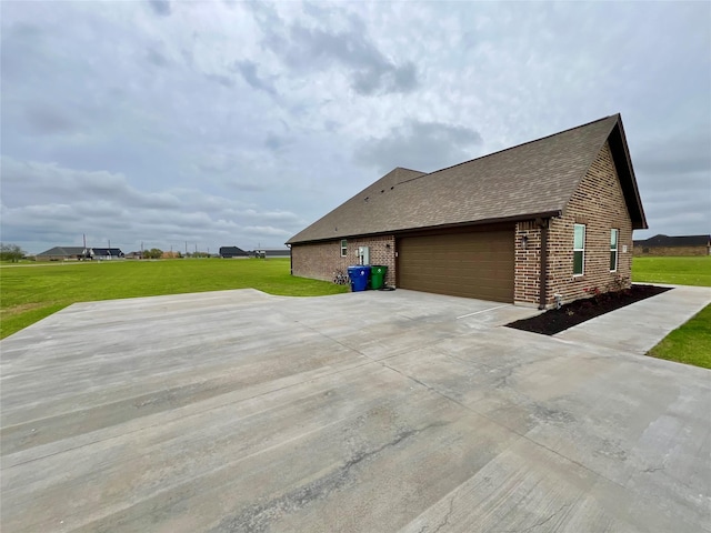 view of home's exterior featuring a lawn, brick siding, concrete driveway, and an attached garage