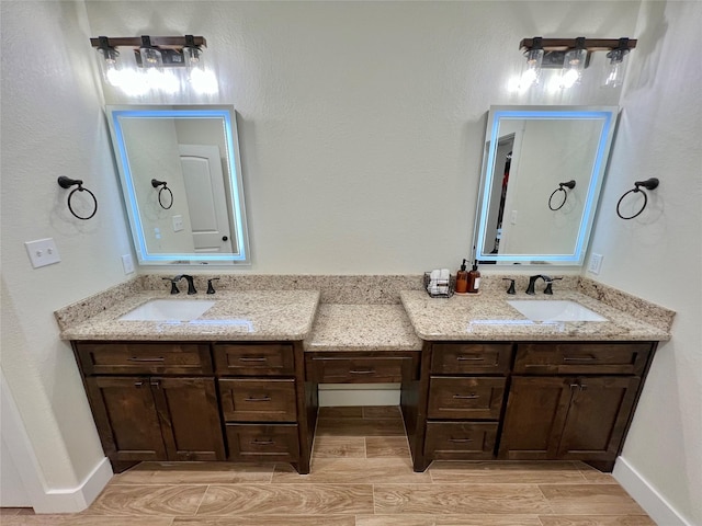 full bathroom featuring double vanity, a sink, and wood finish floors