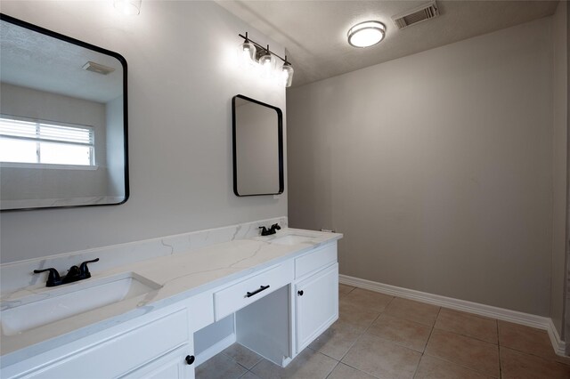 bathroom featuring double vanity, visible vents, a sink, and tile patterned flooring