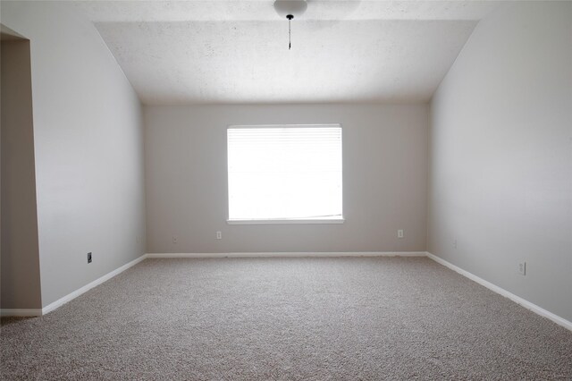 carpeted empty room featuring baseboards