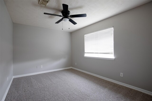 spare room featuring a textured ceiling, carpet, a ceiling fan, baseboards, and visible vents