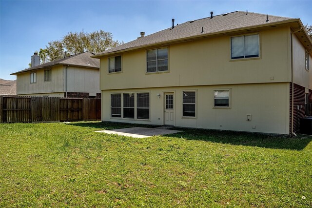 rear view of house with fence, a patio, stucco siding, and a yard