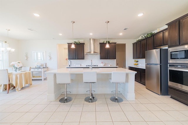 3002 Mildred Hill Ln, Richmond, TX 77406 - kitchen featuring wall chimney range hood, light tile patterned floors, a kitchen breakfast bar, and appliances with stainless steel finishes