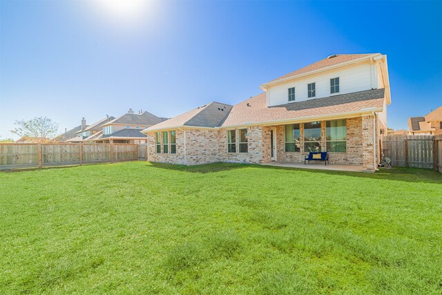 3002 Mildred Hill Ln, Richmond, TX 77406 - rear view of property featuring a patio area, brick siding, a fenced backyard, a shingled roof, and a yard