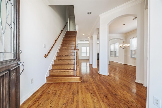 5309 Elm St, Houston, TX 77081 - foyer entrance featuring crown molding, stairs, arched walkways, light wood-style flooring, and a notable chandelier
